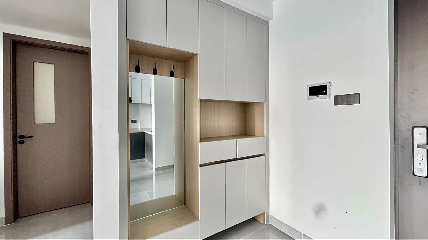 Entryway at Capital Garden, Hurlingham, with grey built-in cabinets, a tall mirror and black coat hooks.