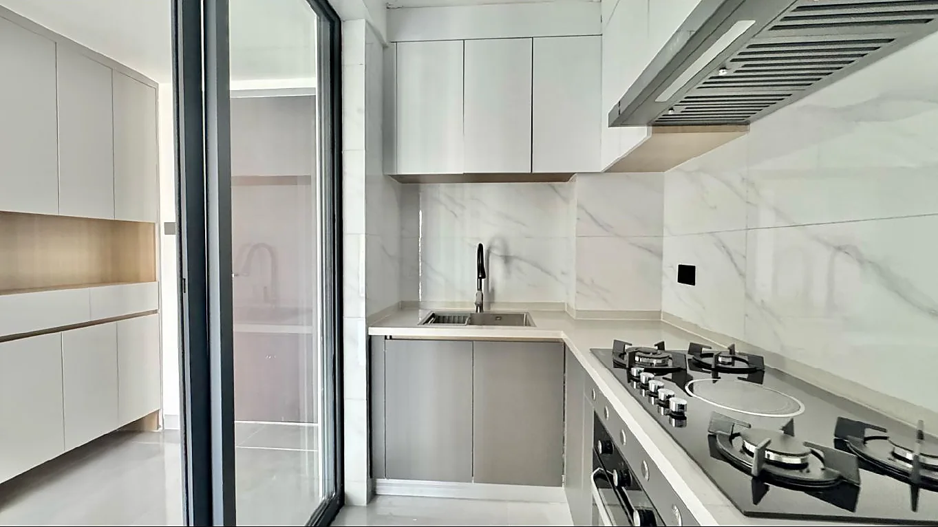 Kitchen at Capital Garden Hurlingham with white wall cabinets, sink, gas hob, oven and extractor hood.