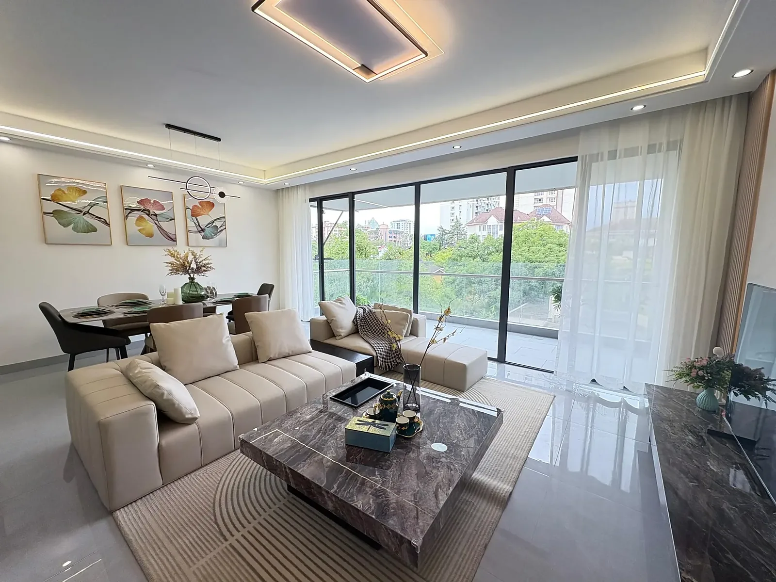 Furnished living and dining area at Capital Garden, Hurlingham, with cream sofas and glass balcony doors.