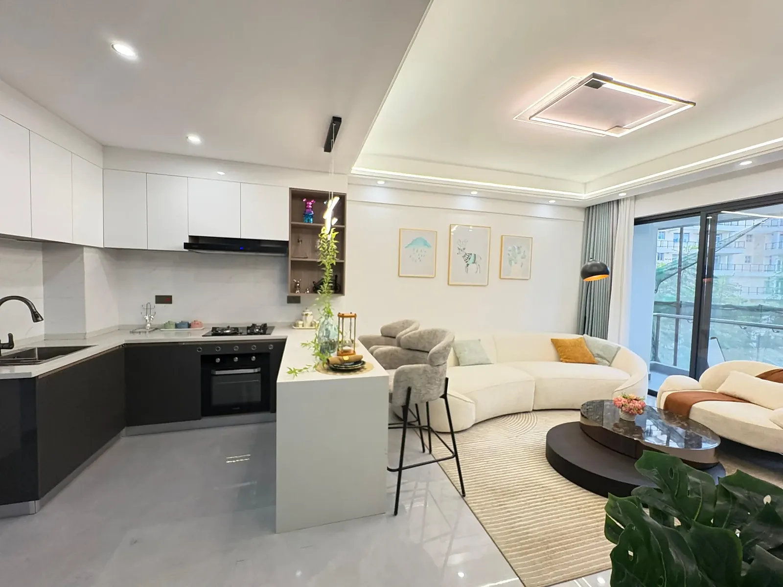 Open-plan kitchen and living area with breakfast bar and curved sofa at Capital Garden, Hurlingham.