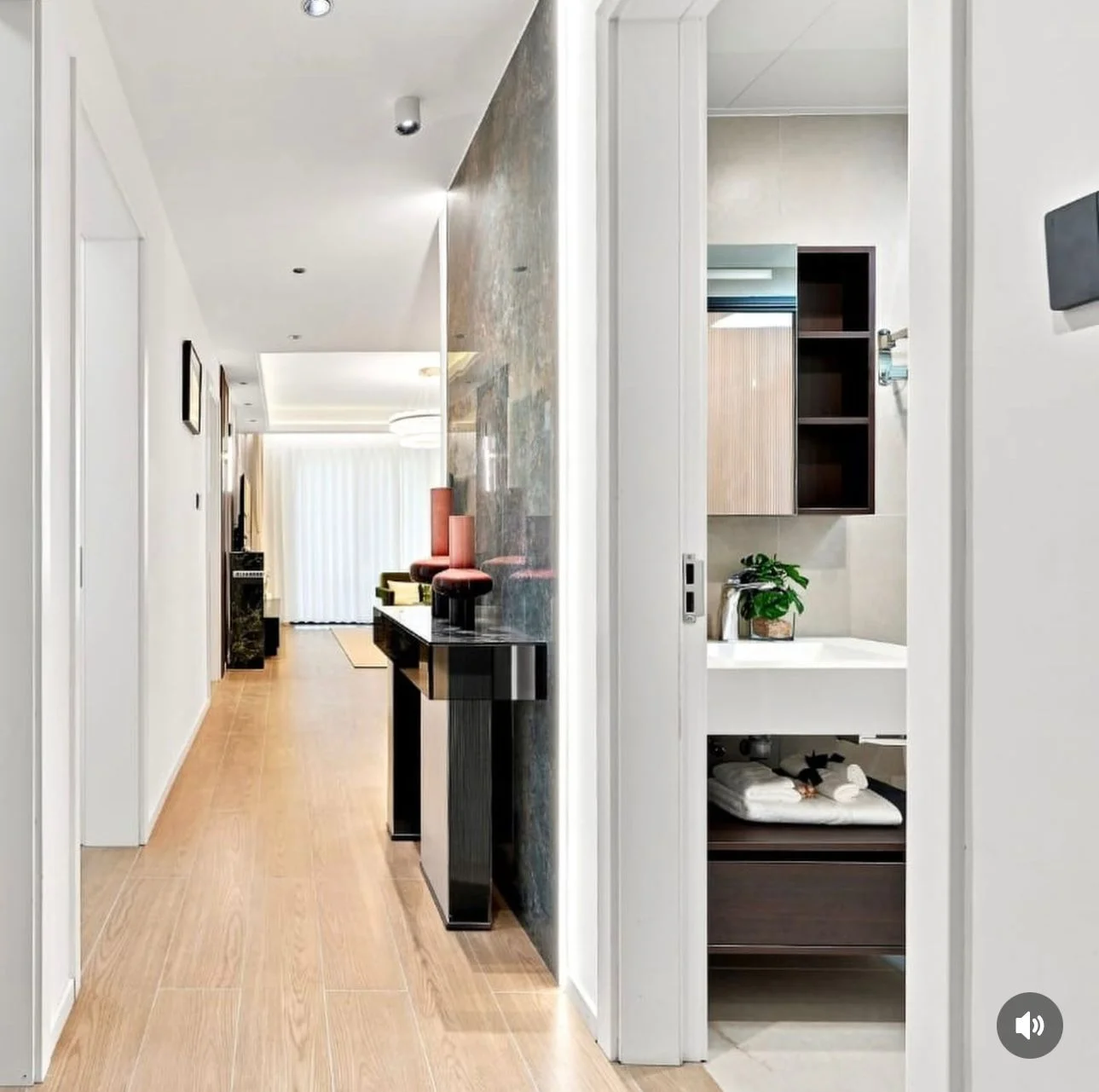Hallway at Capital Heights, Westlands, with wood-look flooring, a black console table and an adjoining bathroom vanity.