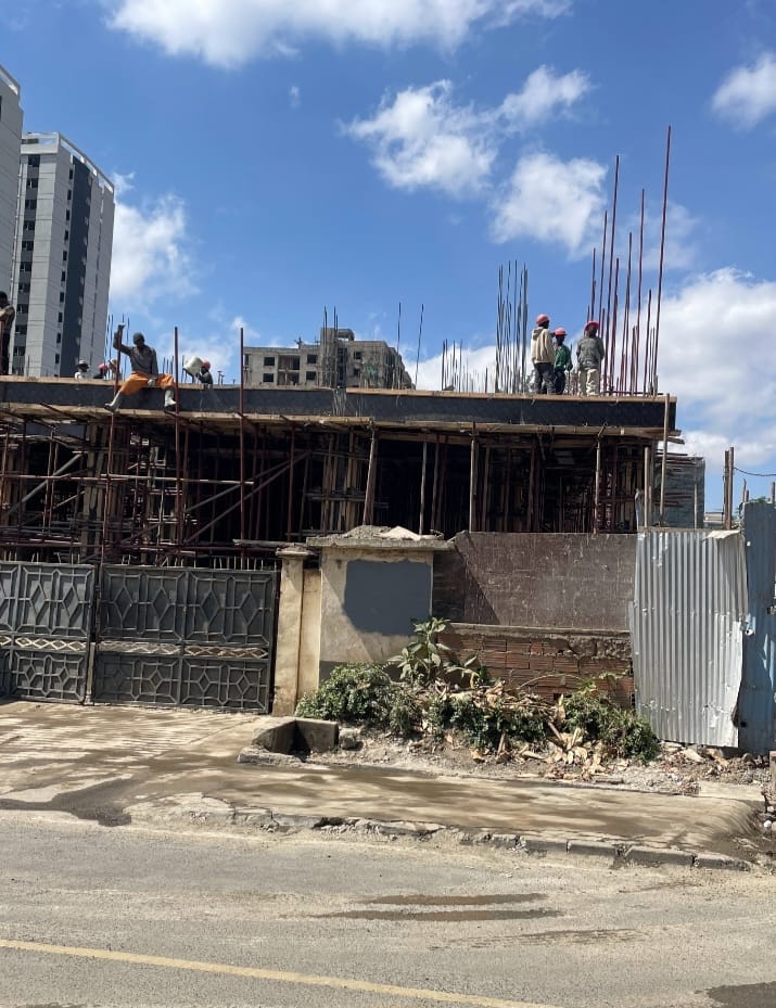 Capital Vista construction site in Kilimani, with workers, scaffolding and exposed steel reinforcement bars.