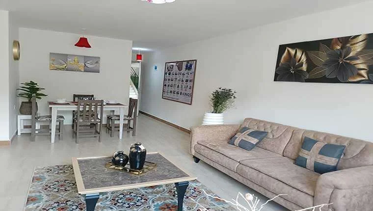Living and dining area at Kings Pinnacle, Westlands, with a beige sofa, coffee table and patterned rug.