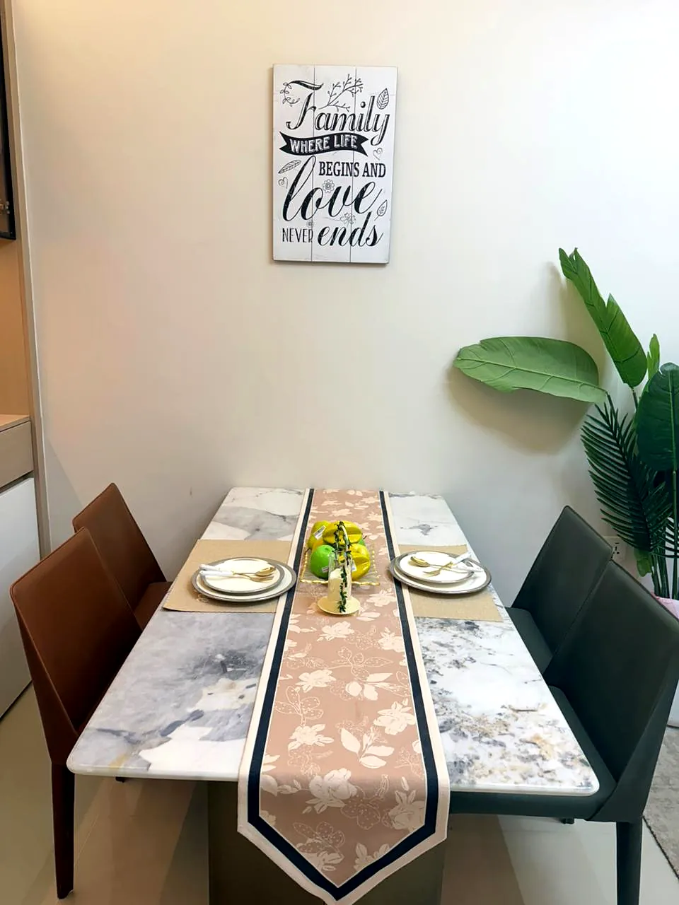 Dining table with a floral runner, place settings and four chairs at Lido Garden Apartments, Kilimani.