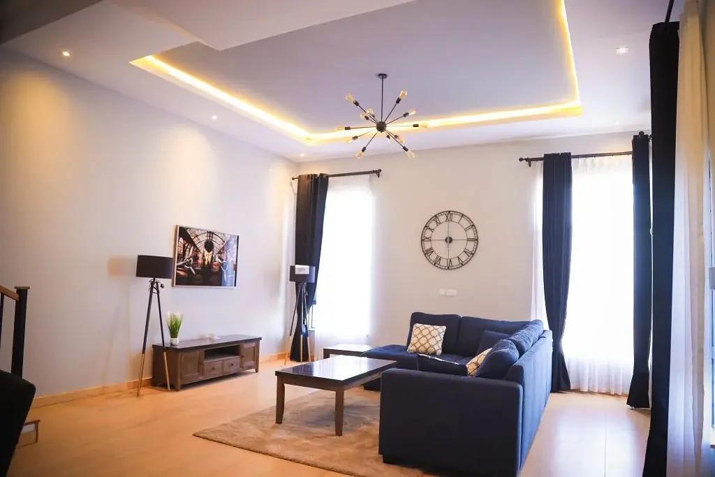 Living room at Marigold II Langata with a blue sectional sofa, coffee table and recessed ceiling lighting.