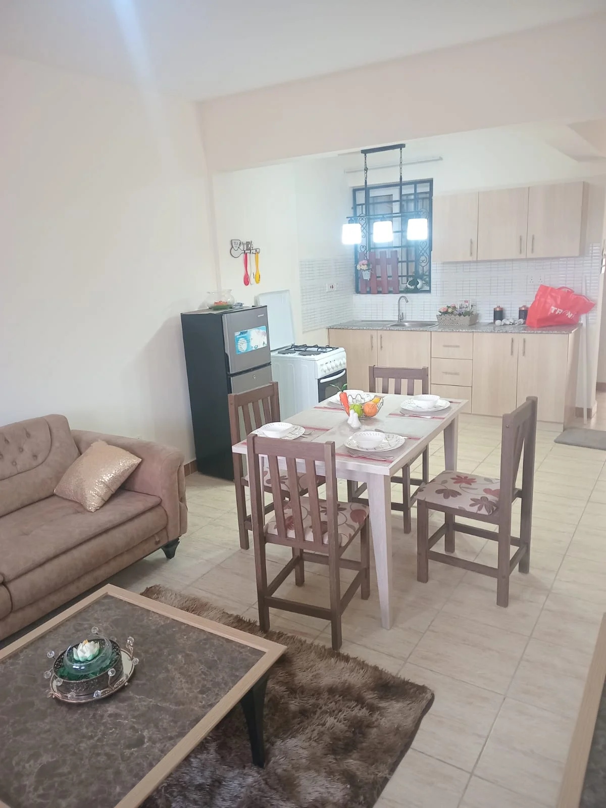 Open-plan kitchen and dining area with a four-seat table and sofa in the apartment on Ngong Road.