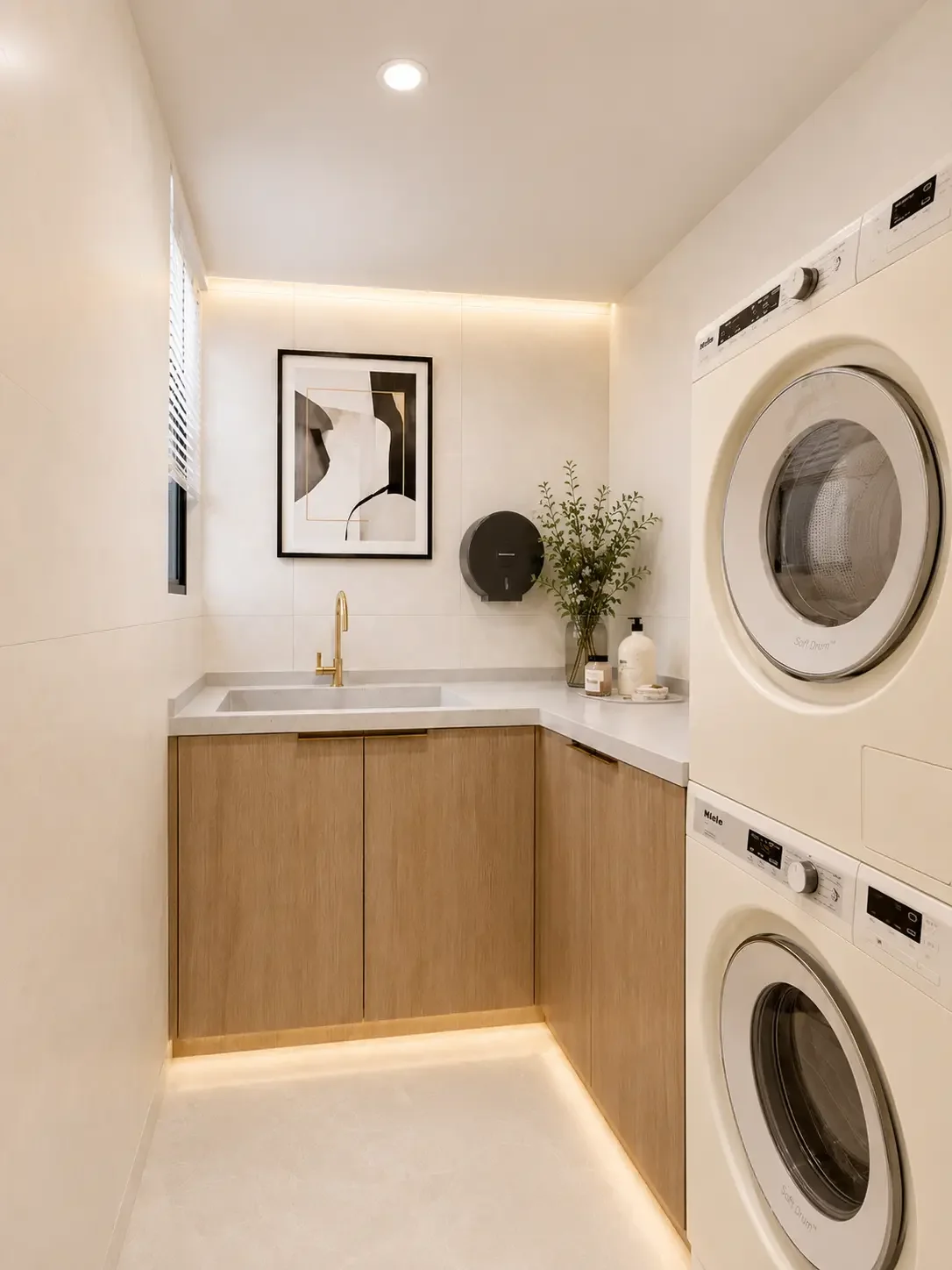 Riverside Azure laundry area with stacked washer and dryer, a sink and wood-look cabinets.