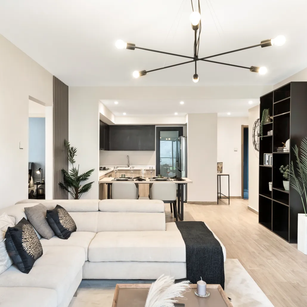 Open-plan living area in South C apartment, with a white sectional sofa, dining table and kitchen beyond.
