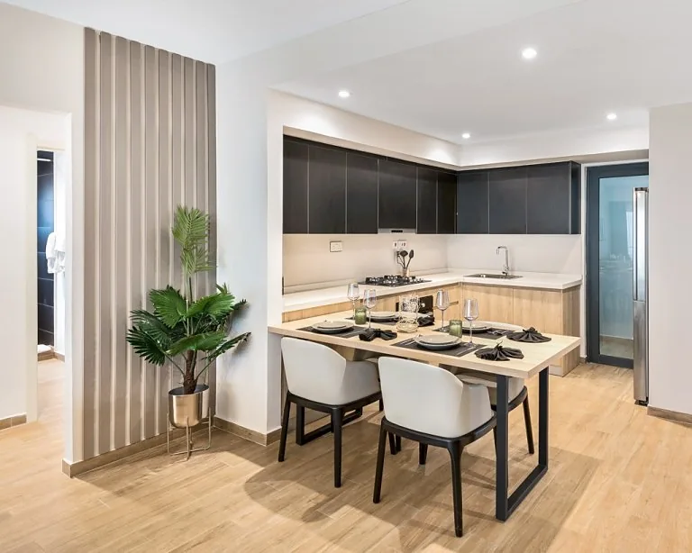 Kitchen and dining area at South Park Apartments, South C, with dark cabinets and upholstered chairs.