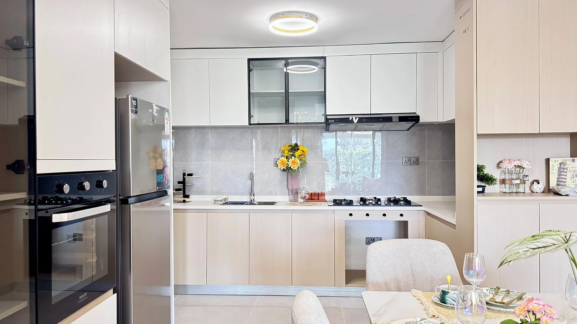 Kitchen at South Park, South C, with pale cabinets, built-in oven, refrigerator and dining table.